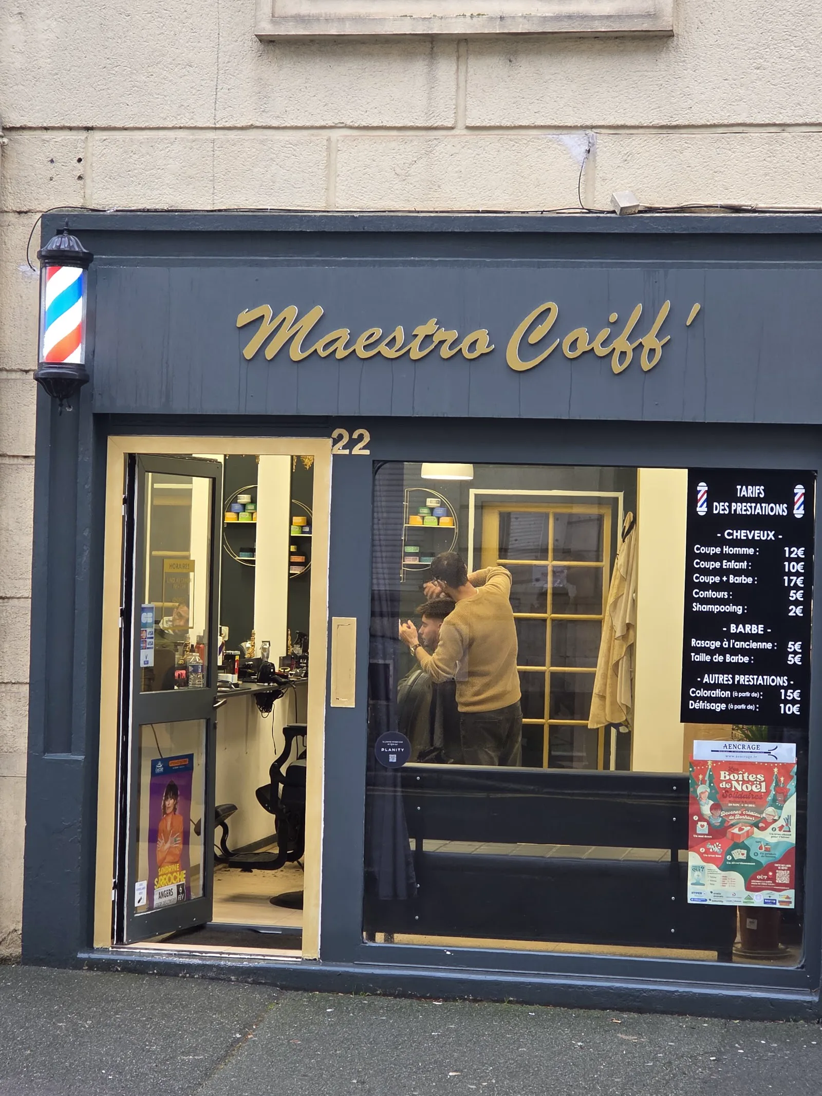 L’enseigne dorée de Maestro coiff’ au-dessus de la vitrine